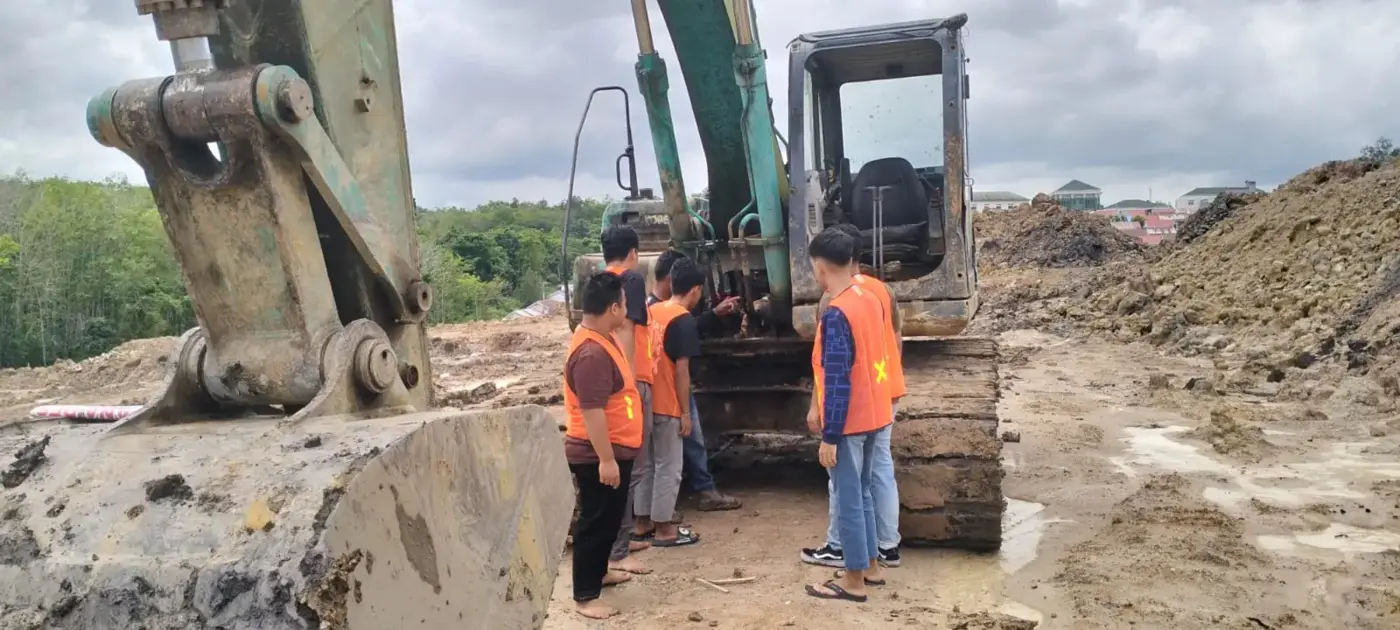 Peserta mempelajari pemeriksaan unit Excavator bersama pendamping di lapangan